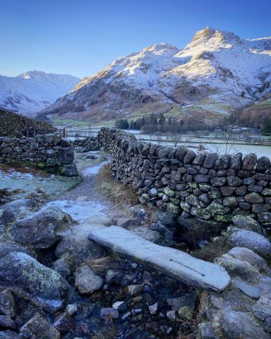 Stone bridge in Langdale Valley in front of the snow covered Langdale Pikes